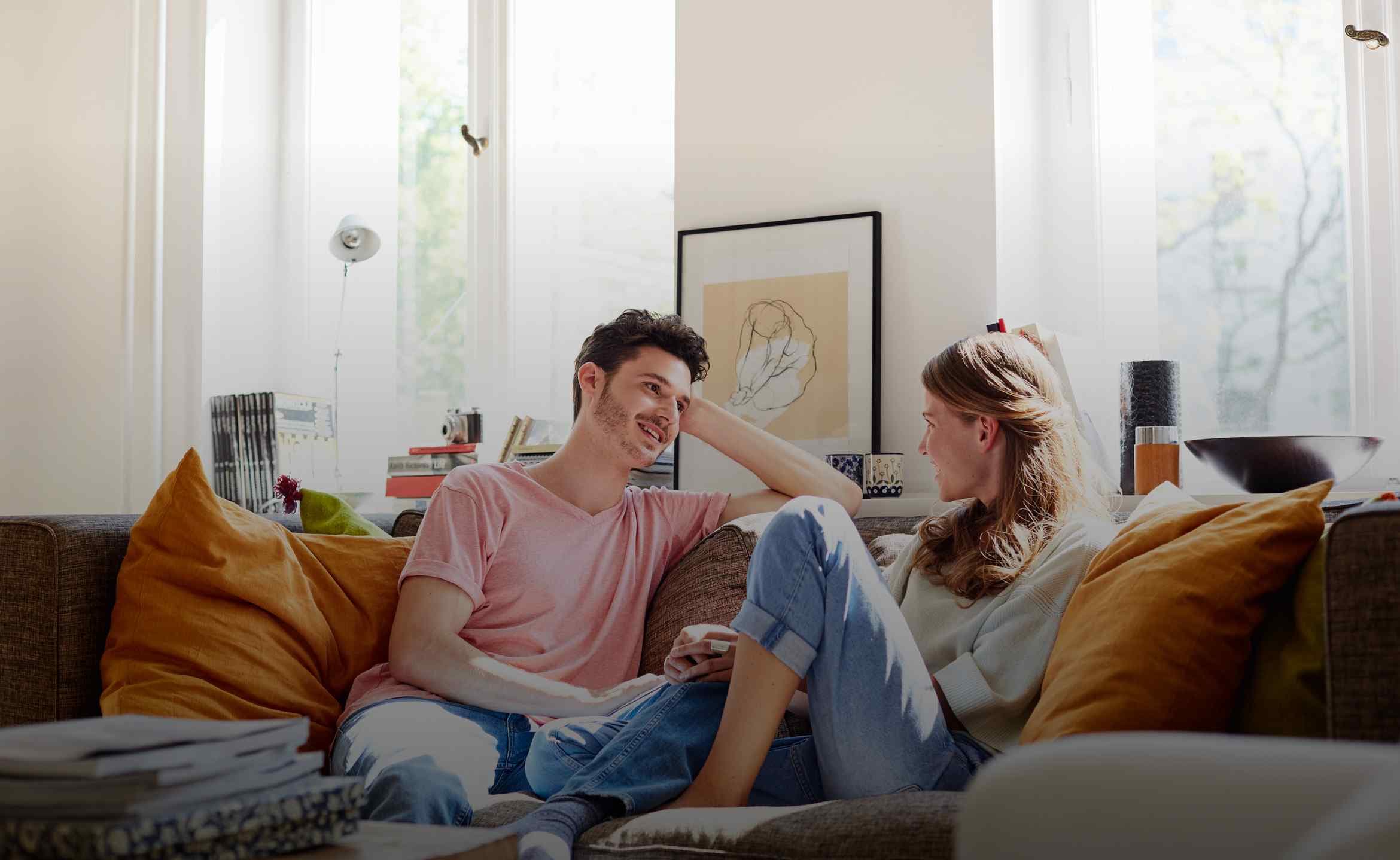 Ein Mann und eine Frau sitzen auf einem Sofa und unterhalten sich